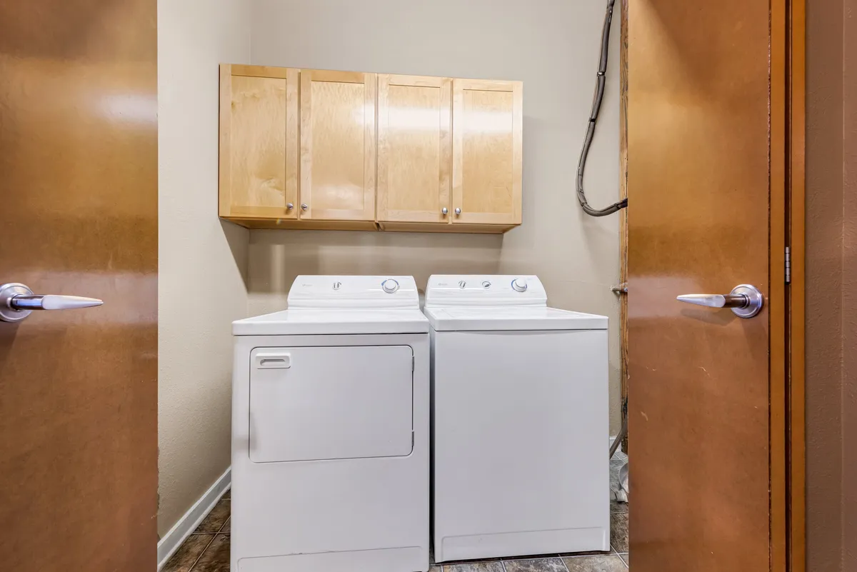 This image presents a well-organized laundry area equipped with a washing machine, dryer, and convenient cabinetry. The space feels efficient and tidy, reinforcing the sense of modern amenities within a classic building setting.